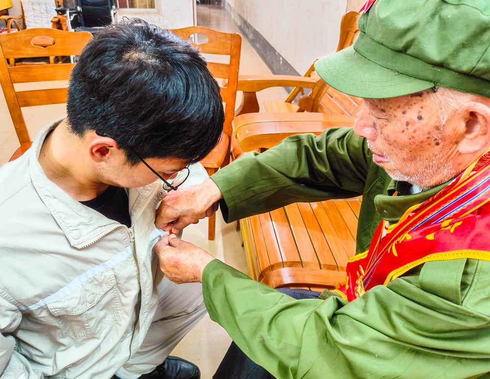 2、韋仕隆給新入黨的青年黨員佩戴黨章--李陽攝.jpg